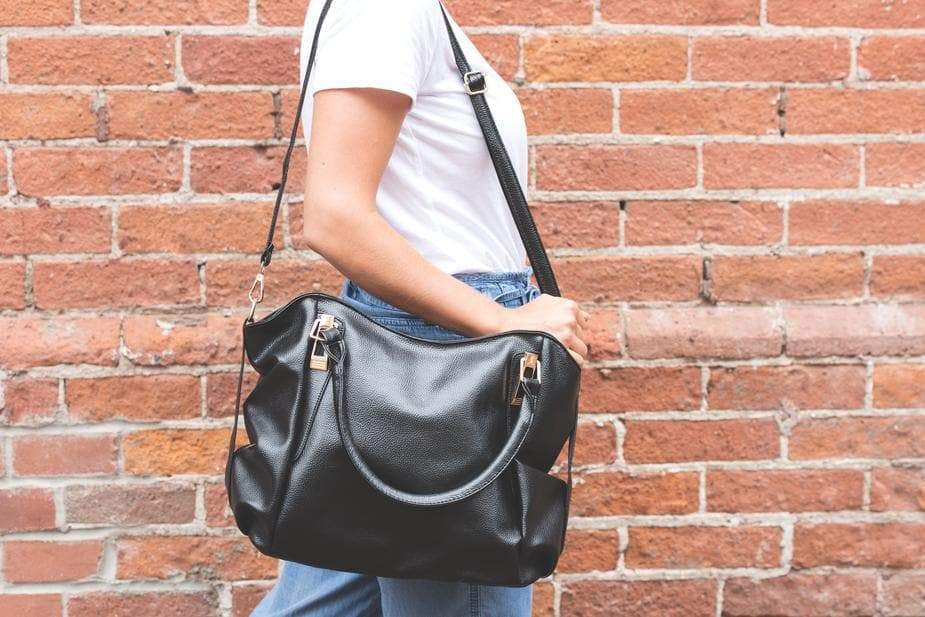 a person with a backpack and suitcase on a brick wall