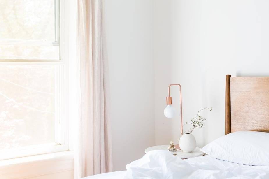 a bed with white sheets and pillows in a room 