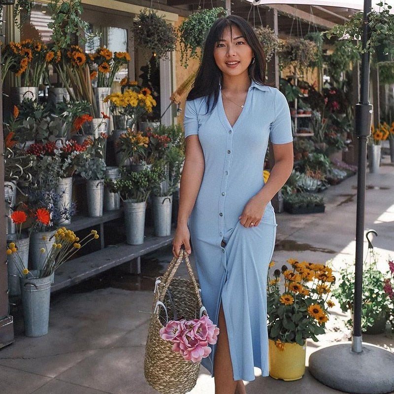 a woman standing in front of a table with a flower 