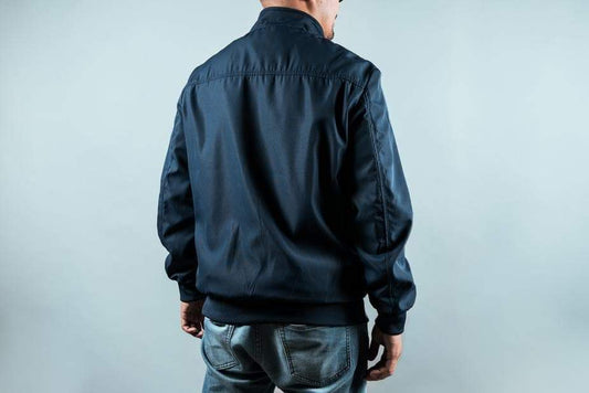 a man standing on a bench holding a backpack 