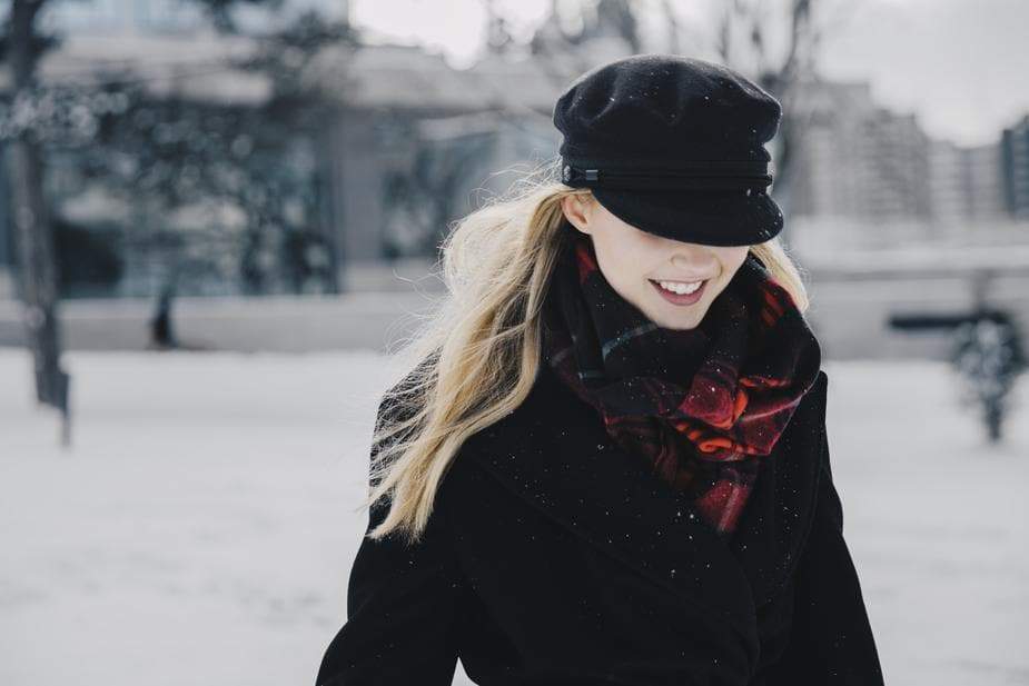 a woman is sitting on a bench in the snow 