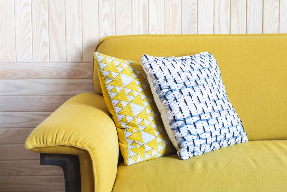 a couch with a yellow pillow and a yellow pillow 
