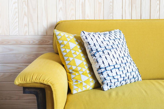 a couch with a yellow pillow and a yellow pillow 